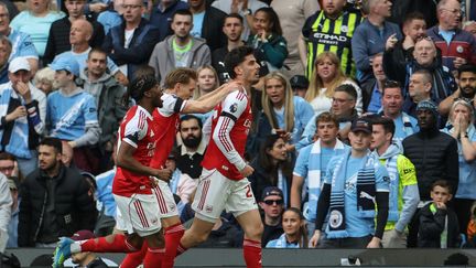 Arsenal players celebrating with trophies after securing Premier League title