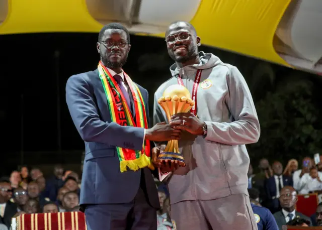 Senegal's president Bassirou Diomaye Faye and national team captain Khalidou Koulibaly holding the Africa Cup of Nations trophy together