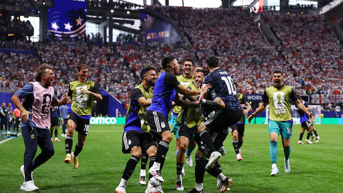 Soccer players celebrate a goal on the field.